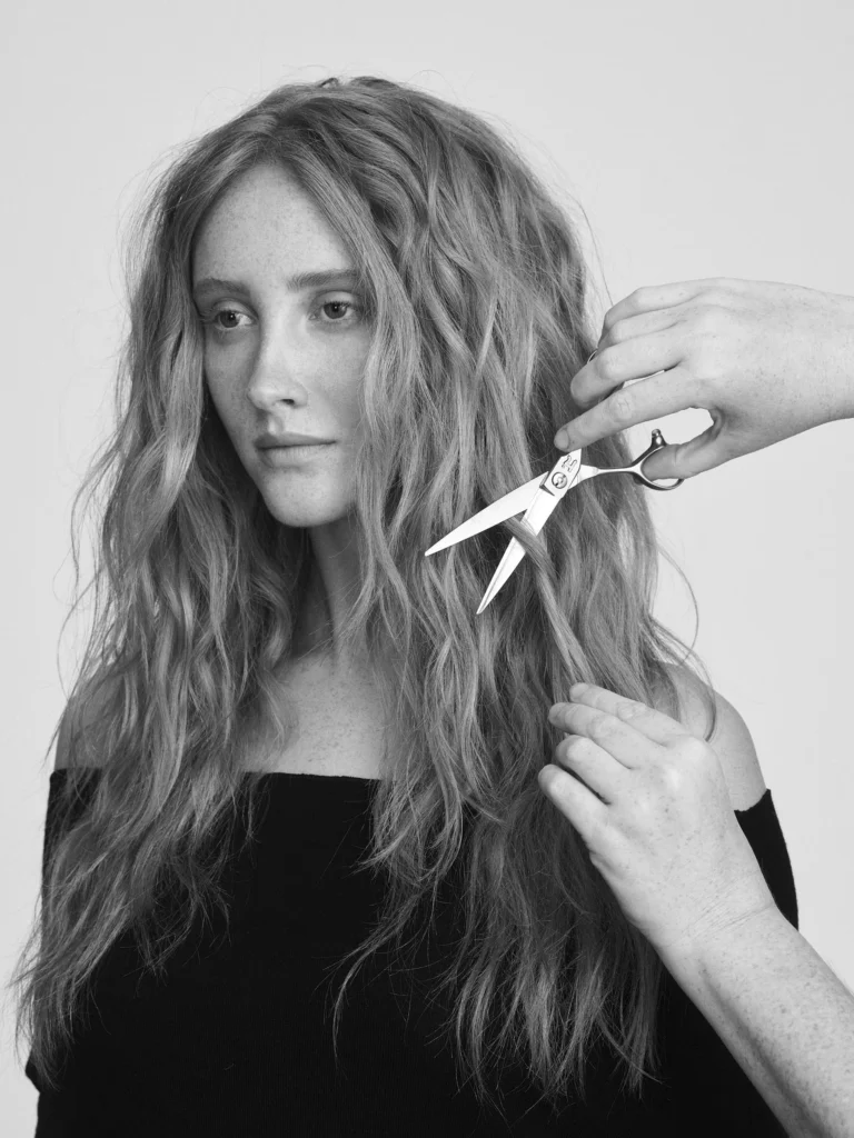 Stylist cutting a client's long hair with Hanzo shears