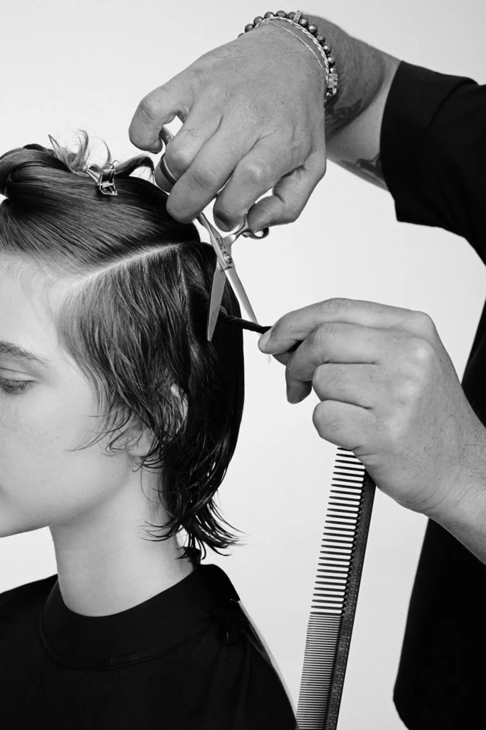 Hanzo educator sectioning and cutting a client's hair