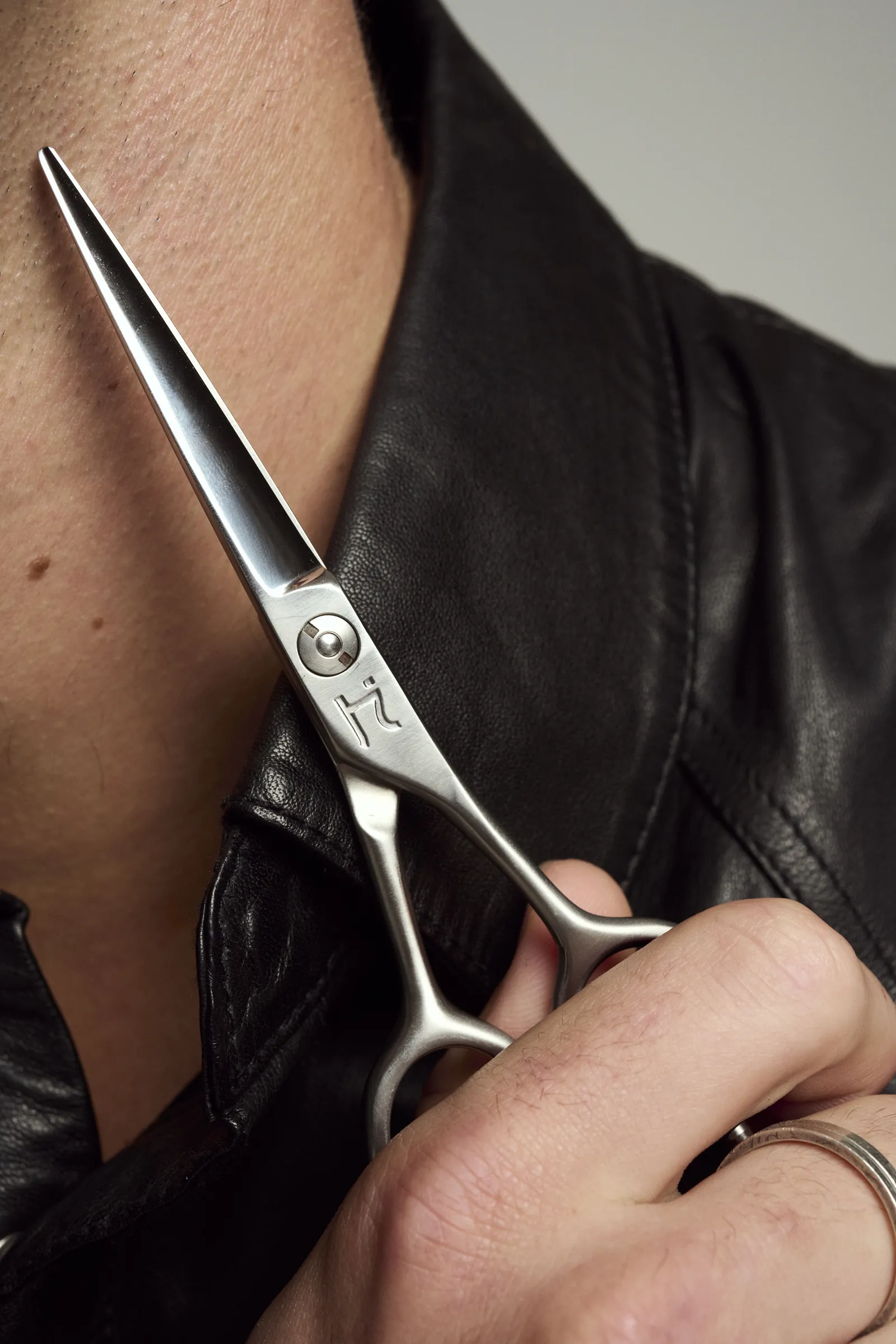 Hanzo shear held against a leather jacket